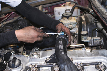 The mechanic is checking the engine.