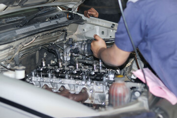 The mechanic is checking the engine.