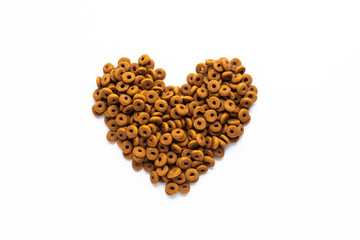 Dried dog food with a shape of heart on white background. Top view Brown grain pet food banner background with copy space of text design.