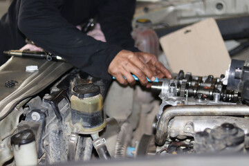 The mechanic is checking the engine.