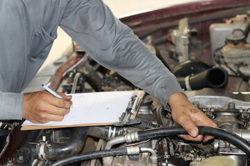 The mechanic is checking the engine.
