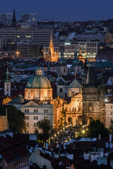 View of the centre of Prague and Charles Bridge in the evening with night illumination. Tourism. Towers of Prague. Czech Republic
