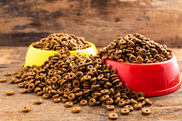 plastic bowl full with dry dog food on wood background. Top view grain pet food with copy space of text design. Above or Top view. food texture banner..