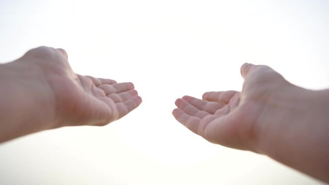 Closeup point of view video footage of two female hands raised up to sunny white sky natural background