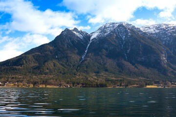 View idyllic Alpine mountains, lake Hallstattersee and small houses in valley. Sunny morning in Austria