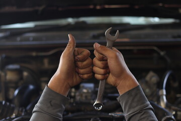 The mechanic is checking the engine.