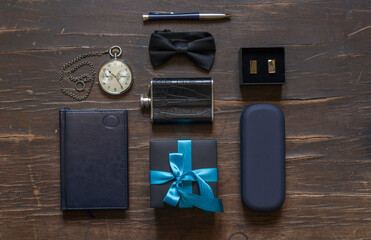 Men's accessories, bow tie, pocket watch on chain and others and gift box with blue ribbon, top