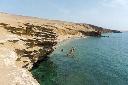 Beautiful beach in paracas national parc, Peru. Kayak navigating the turquoise crystal clear water.