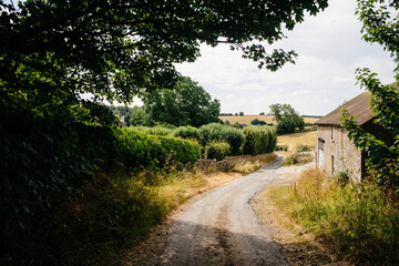 winding path in english countryside next to cottage