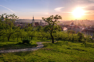 View of Prague from Petrin garden with the road in the foreground and sun rays coming through the fog