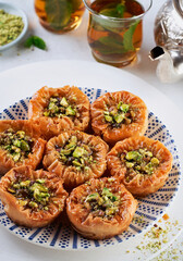 Fototapeta na wymiar Middle eastern arab sweet pastry baklava with honey, pistachios, mint tea on a light background. Selective focus. Ramadan, Eid concept.