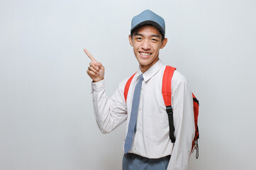 Indonesian Senior Student wearing uniform pointing at copy space or blank space
