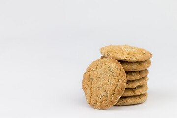 Cereal cookies are superimposed on top of each other, with one piece leaning on the side. The cookies are brown and the images are blank on the side of the object and have a white background.