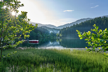 Beautiful landscape photo of Karagol / Karagöl Lake, surrounded by trees with boars on dock,...