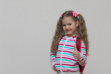 Back to school. Portrait fair-haired school girl with bag. Light grey studio background. Education. slooking and smiling at camera. copy place.