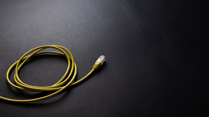 LAN cable, Ethernet RJ45 cable on black texture background, desk from top view, copy space. 