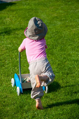 Little girl with hat running in the grass