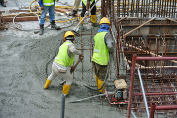 SELANGOR, MALAYSIA -JUNE 18, 2016: Construction workers using a concrete vibrator at the...