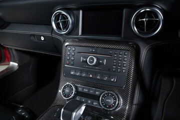 Fototapeta na wymiar Carbon fiber control buttons in luxurious car interior