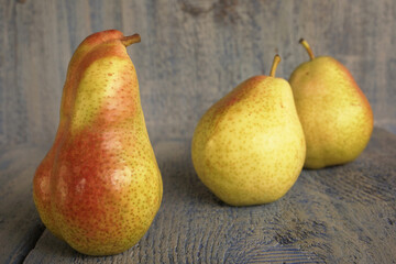 Three beautiful juicy ripe whole pears on a blue wooden background. Concept of a fruit diet        