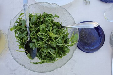 A bowl of rocket salad on a table in a garden at lunchtime in Bavaria, Germany.