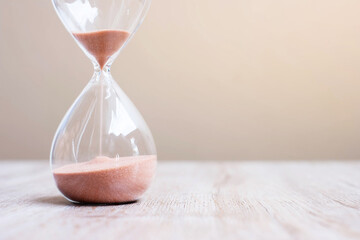 Hourglass on table, Sand flowing through the bulb of Sandglass measuring the passing time. countdown, deadline, Life time and Retirement concept - obrazy, fototapety, plakaty