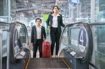 Fototapeta premium Business man standing on an escalator at an airport terminal traveling abroad