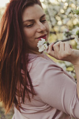 Portrait of a young girl with a blossoming apple tree