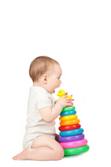 Obraz premium Cute baby playing with colorful rainbow pyramid isolated on a white background. Child with educational toy.