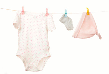 Baby clothes hanging on the clothesline isolated on white.