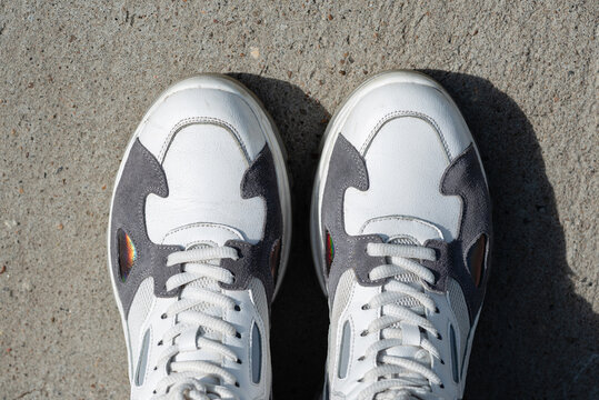 Sneakers on the pavement in bright sunlight.
