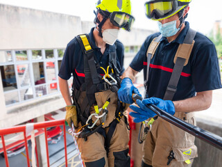 Fototapeta premium Firefighters in vertical rescue practices during a training exercise Rescue concept
