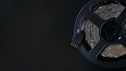 LED tape coil. LED lights tape on black background. RGB-light off