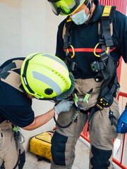 Fototapeta premium Firefighters reviewing tools in vertical rescue practices during a training exercise Rescue concept