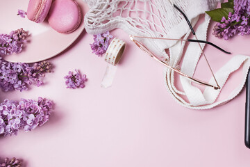 Spring flat lay with lilac flowers, glasses and macarons