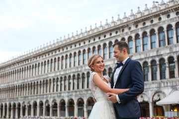 Fototapeta na wymiar Happy beautiful wedding couple posing in venice square