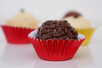 Close up de Brigadeiro com Beijinhos ao fundo. Doces brasileiros. Festa infantil. Chocolate e coco. Aniversário. 