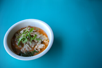 Pork suki in a white cup on a blue background