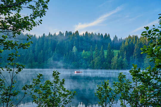 Man is rowing a boat on the foggy lake Karagol / Karag&ouml;l at sunrise. Landscape photo was taken in Savsat / Şavşat, Artvin, Karadeniz / Black Sea region of Turkey