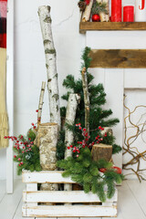Natural Christmas decorations in white interior. Rustic decoration. White wooden box with spruce branches