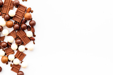 Candy background with chocolate on white table top view frame. Sweets desserts concept. Space for text