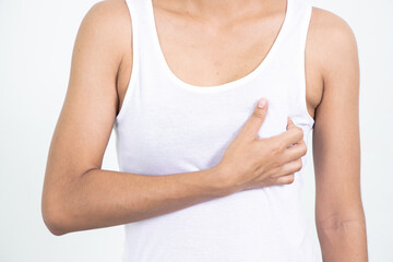 Woman hand checking lumps on her breast for signs of breast cancer on gray background. Healthcare concept.