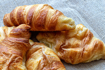 Few croissants on a canvas tablecloth