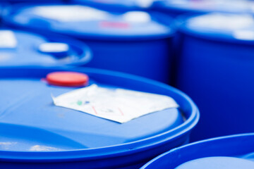 blue plastic barrels with poison in close-up with blur in background