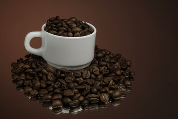 White mug with coffee grains sprinkled with coffee grains on a background