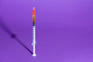 Syringe on purple color background