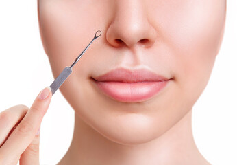 Young woman with acne loop. Squeeze the acne with acne spoon. Isolated on white background.