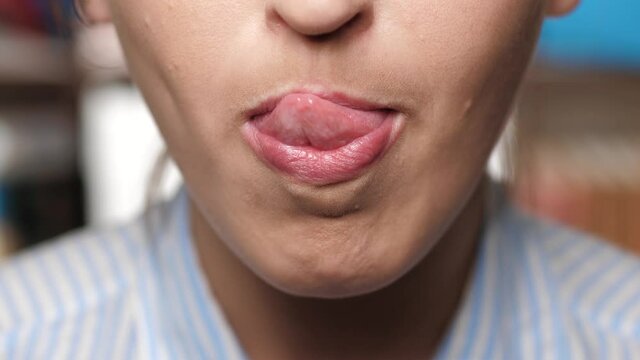 Woman licks her lips. Girl runs her tongue first on her upper lip and then on her lower