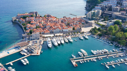 Budva Montenegro - famous summer vacation tourist destination on the coast of turquoise Adriatic sea. Medieval old town and marina for small boats and yachts on the  Mediterranean in south Europe.
