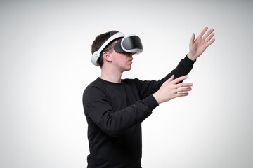 Side view portrait of a man in VR glasses, pointing up with his hand